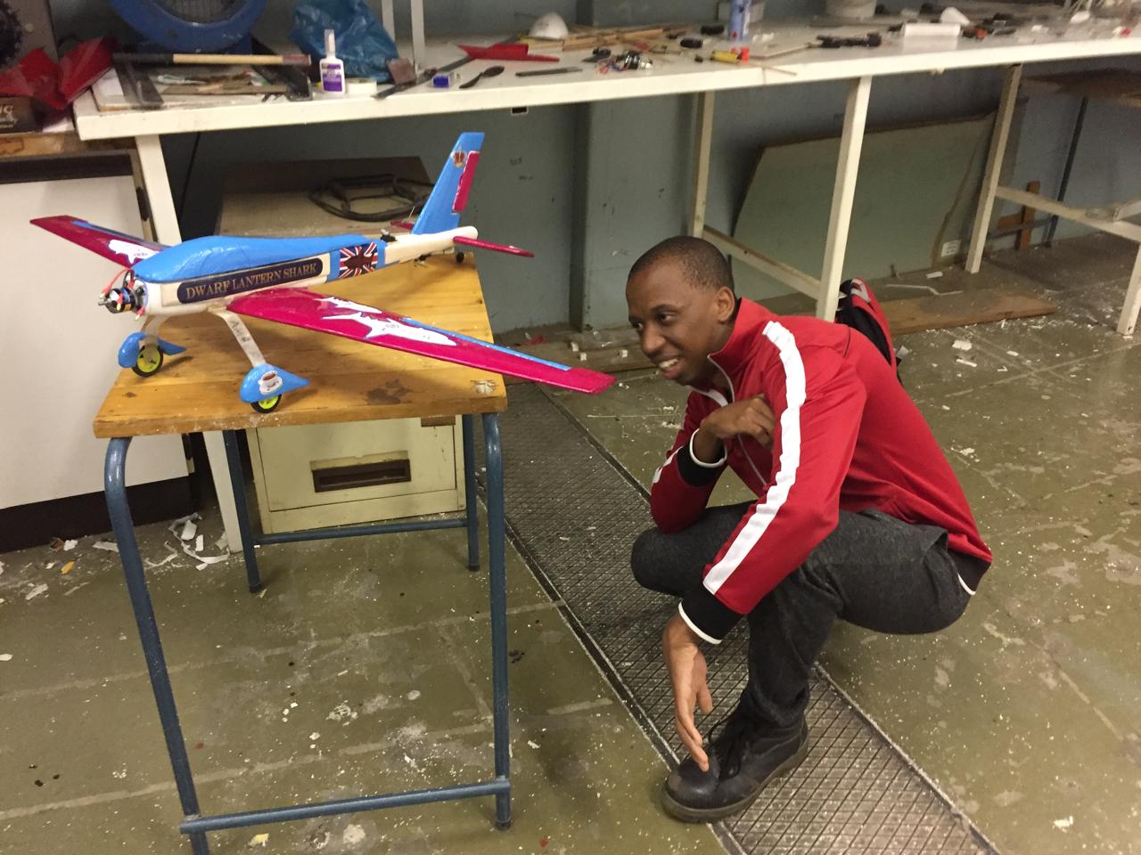 Njabulo beside a model aircraft in the workshop