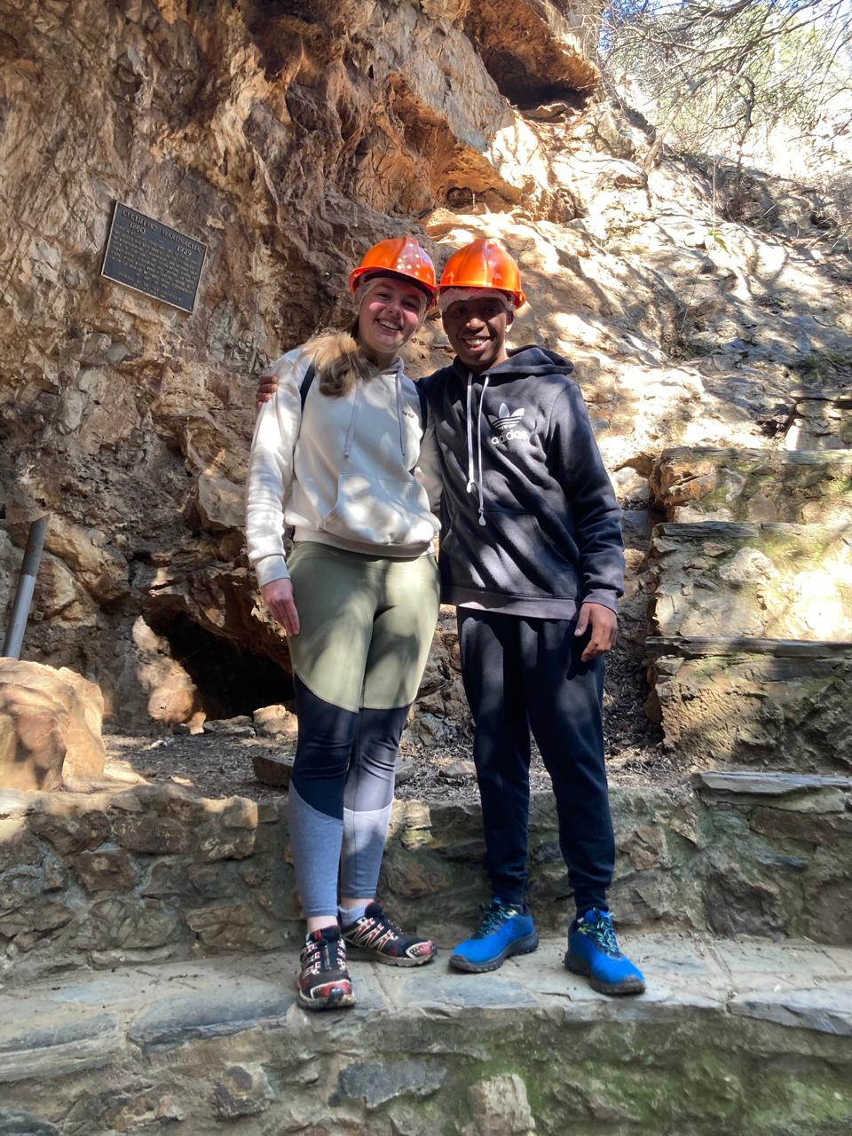 Njabulo and Uma wearing helmets on a cave adventure